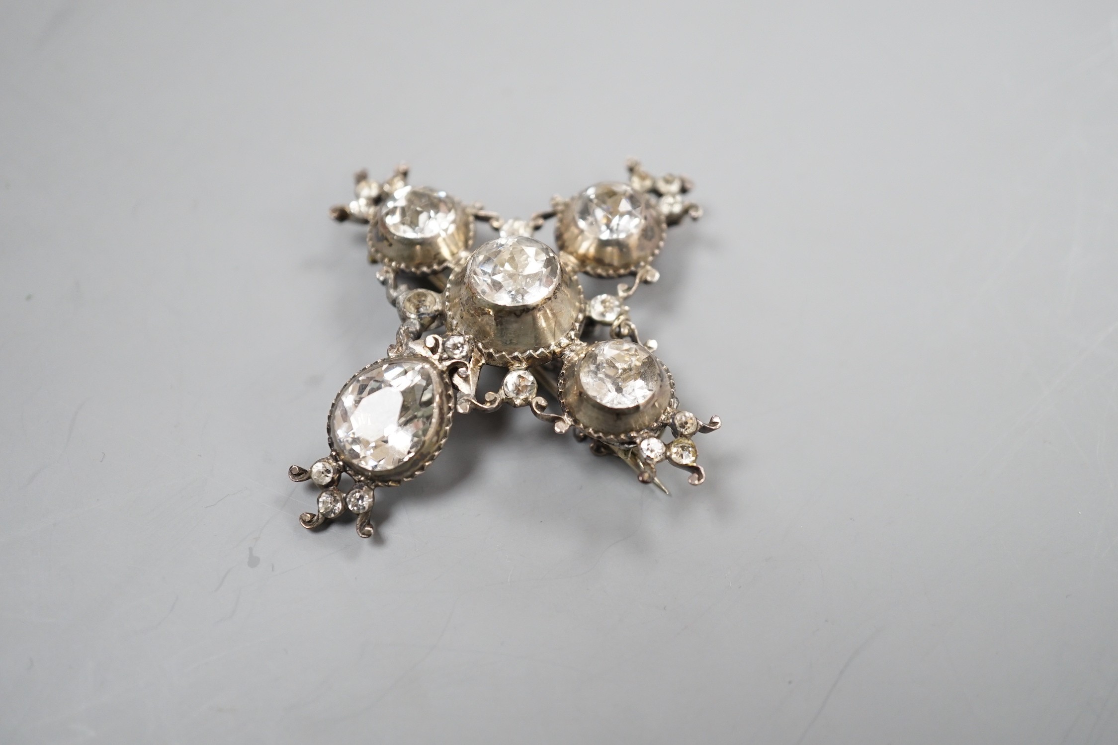 A 19th century white metal and paste cluster set quatrefoil shaped pendant brooch, 56mm, (a.f.).